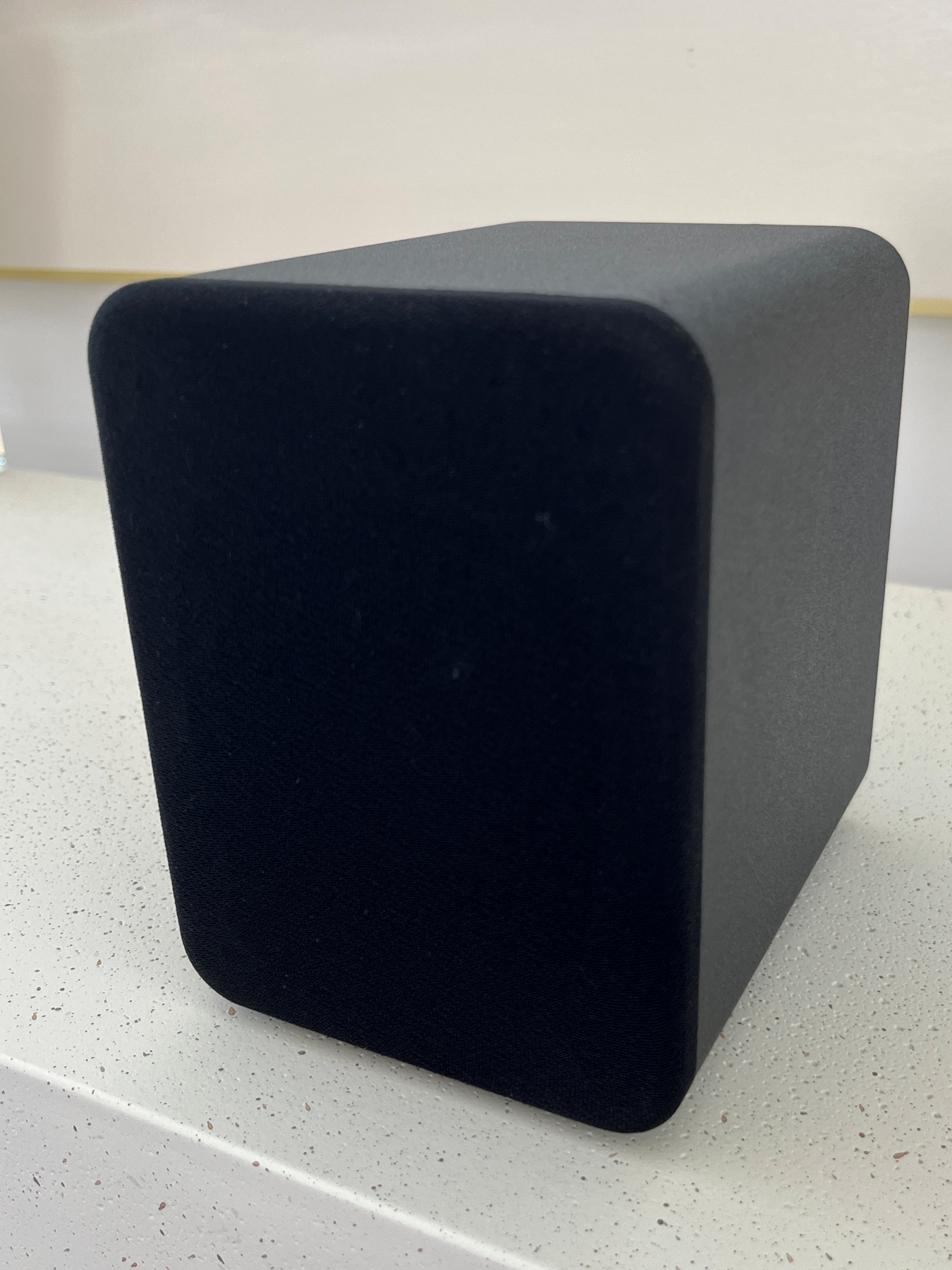 HouseWaves One front angle view — matte black bookshelf speaker with grille, compact Home Assistant audio speaker